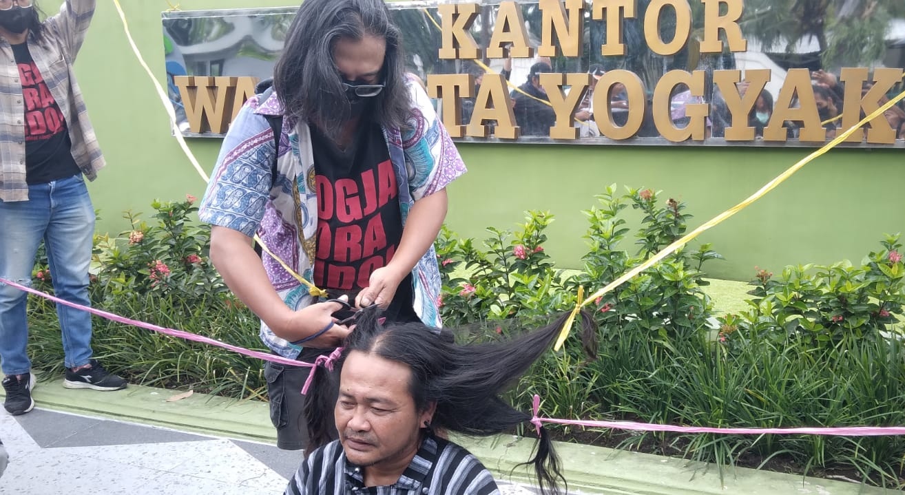 Warga Cukur Gundul di Balaikota Jogja Merespons Penangkapan Haryadi Suyuti Oleh KPK Dodok Putra Bangsa saat melakukan aksi cukur gundul atas terungkapnya kasus korupsi suap yang menjerat mantan Walikota Jogja, Haryadi Suyuti pada Sabtu (4/6/2022) di depan komplek Balaikota Jogja. - (foto: Deny Hermawan)